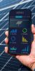 Gehaltenes Handy mit einer graphischen Übersicht vor Solarpanelen