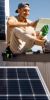 Mann mit Tablet auf einem Dach mit Solarpanelen